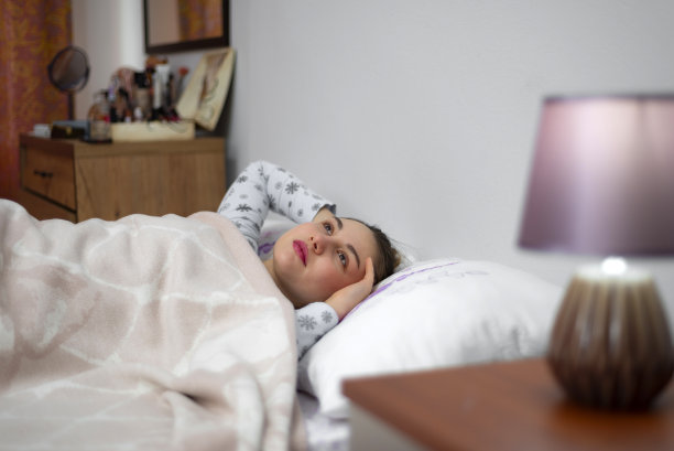 抑郁的小女孩躺在床上。图片下载