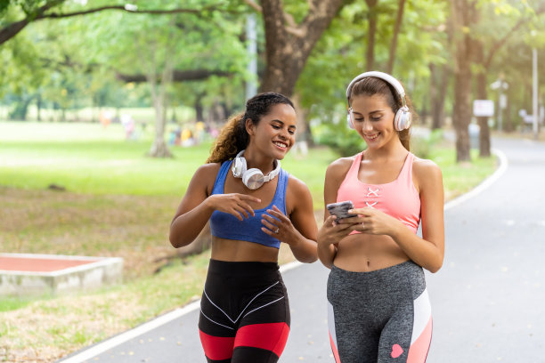 这两名女性是朋友，为了健康，她们经常在公园散步和慢跑，听着愉快的音乐放松。图片下载