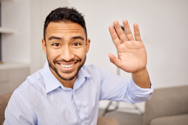 一个年轻的商人在视频通话中挥手图片下载