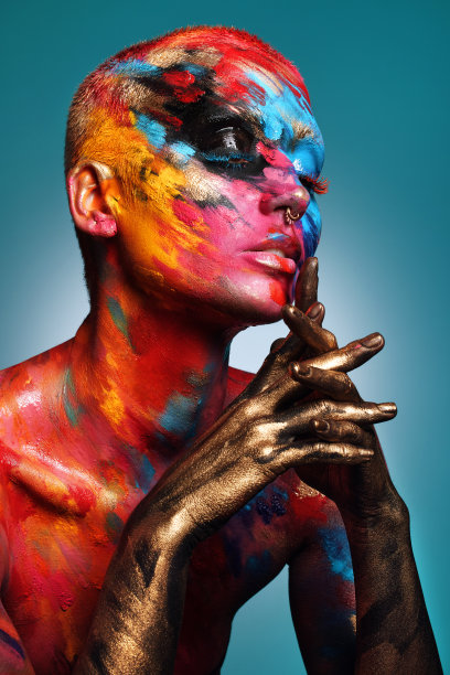 这张照片拍摄的是一名迷人的年轻女子独自在画室里摆姿势，脸上和身上都涂着颜料图片下载