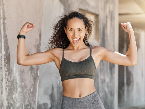 这张照片拍摄的是一个有魅力的年轻女子独自站在那里，在城市的户外锻炼中展示她的肌肉图片下载