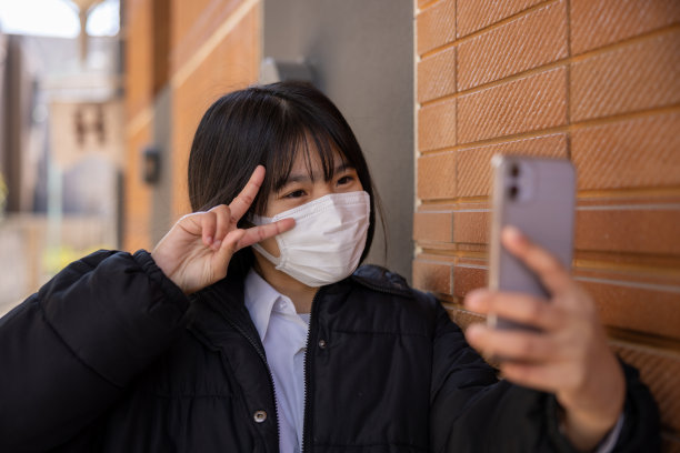 十几岁的女孩在街上自拍，做着和平的标志图片下载