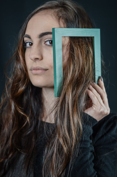 骄傲的我的长自然头发-年轻美丽的女孩持有一个小框架在她的手在她的长自然的头发图片下载