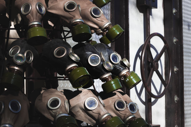 这是一张完整的黑色图片，上面是一排排带着亮绿色滤光片和蓝色玻璃目镜的防毒面具。机座侧面装有圆阀的燃料舱图片下载