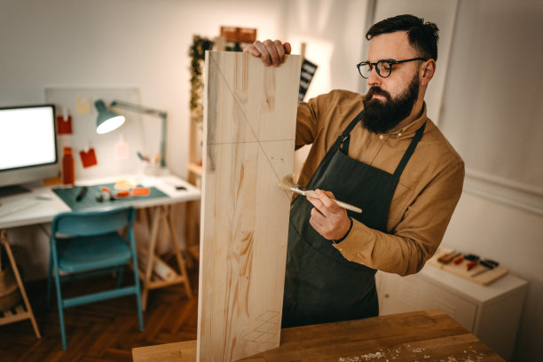 男艺术家在工作室工作台上清理木头上的灰尘图片下载