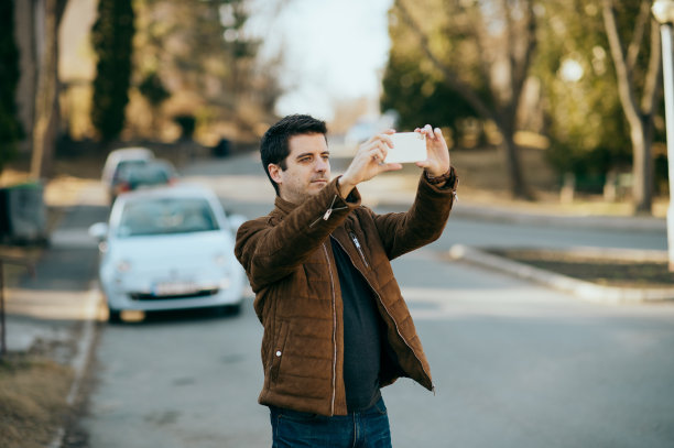 一个年轻人在用手机拍照。图片下载