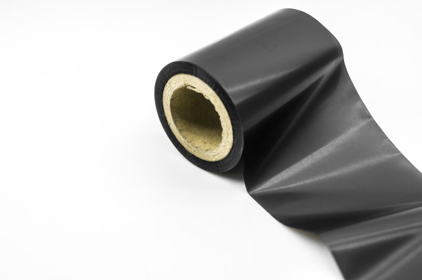 黑色热转印带- TTR。为条码在硬纸板卷轴上打蜡。为印刷行业提供材料。选择性聚焦，孤立在白色上图片下载