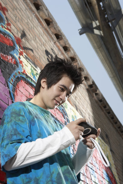 街头玩游戏机的男子图片下载