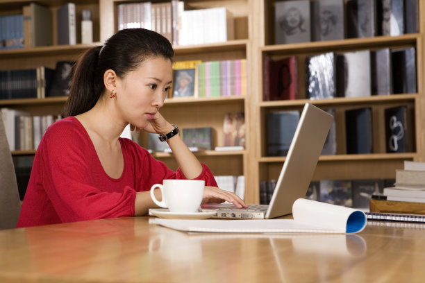 年轻女子使用笔记本电脑图片下载