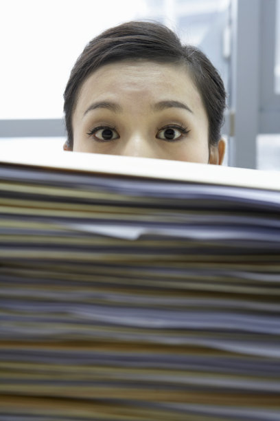 大摞文件后的商务女性图片下载