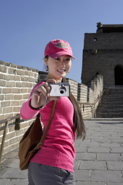 一位来郊游的女孩正在长城上拍照图片下载