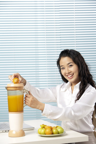 年轻女孩使用榨汁机图片下载