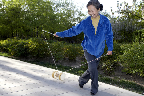 老年女子在公园玩空竹图片下载
