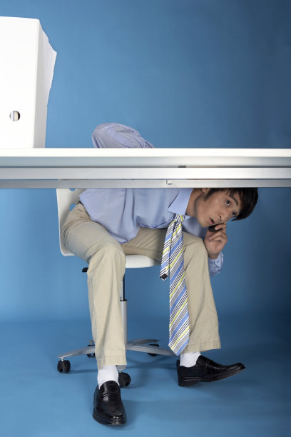 商务男士在桌子下打电话图片下载