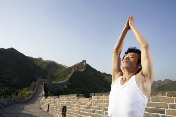 年轻男子在长城做瑜伽图片下载