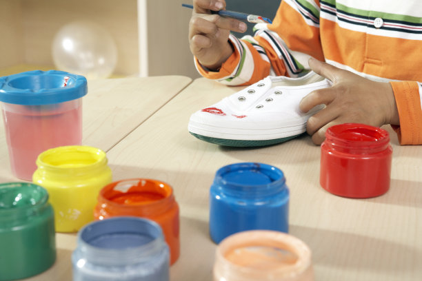 小男孩给鞋子涂色图片下载