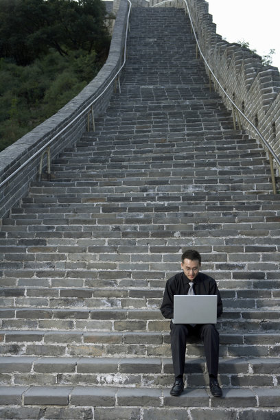 商务男士在长城上使用笔记本电脑图片下载