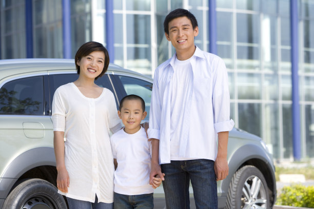 一家三人在车前面对镜头笑图片下载