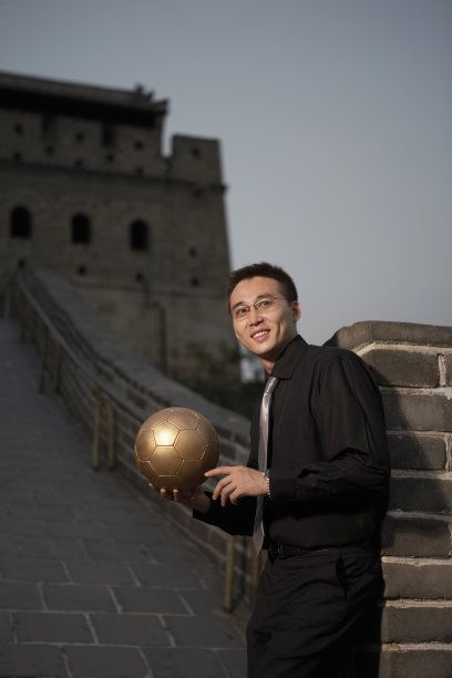 商务人士在长城上手拿足球图片下载