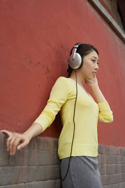年轻女子在城墙外听音乐图片下载