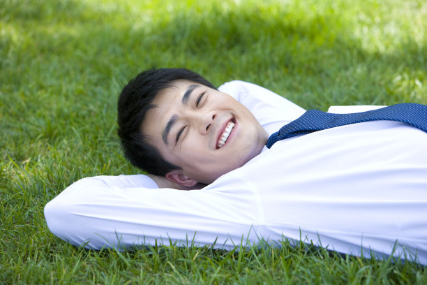 躺在草地上的年轻男子图片下载
