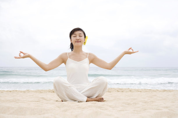 女子海边瑜珈盘腿展开双手图片下载