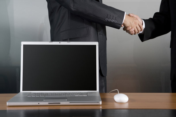 握手的商务男士和笔记本电脑图片下载