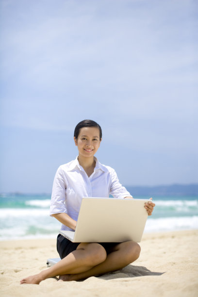 商务女士在海边用笔记本电脑图片下载