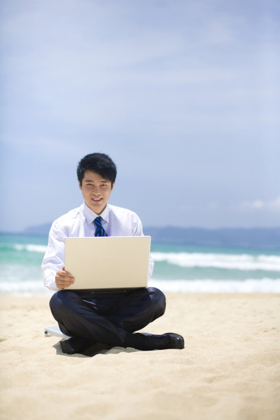 商务男士在海边用笔记本电脑图片下载