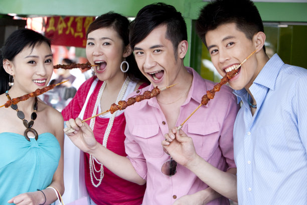 时尚青年街头吃羊肉串图片下载