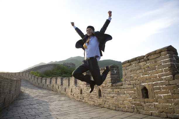 商务男士在长城跳跃图片下载