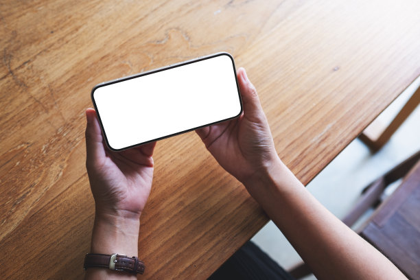 俯视图模型图像的一个女人持有的手机与空白的桌面屏幕图片下载