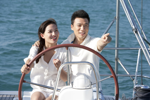青年夫妇驾帆船航海图片下载