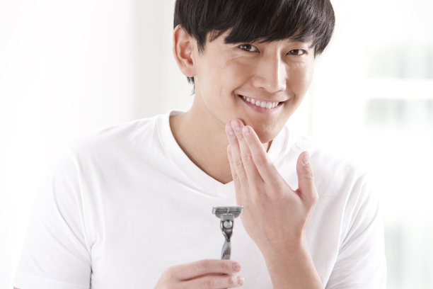 拿剃须刀的年轻男性图片下载