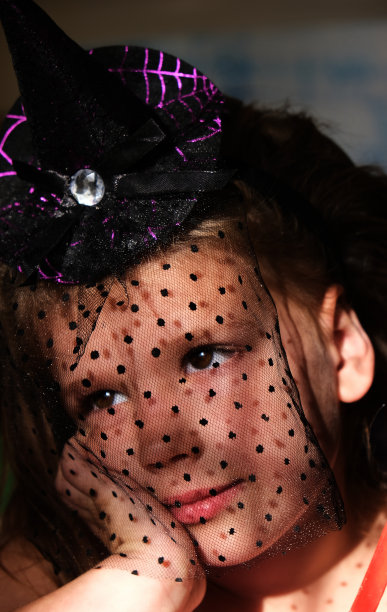 美丽体贴的小女孩，戴着黑色的面纱，在剧院里观看一场感人的表演。电影的肖像。在舞台上的表现。融合儿童观念。图片下载