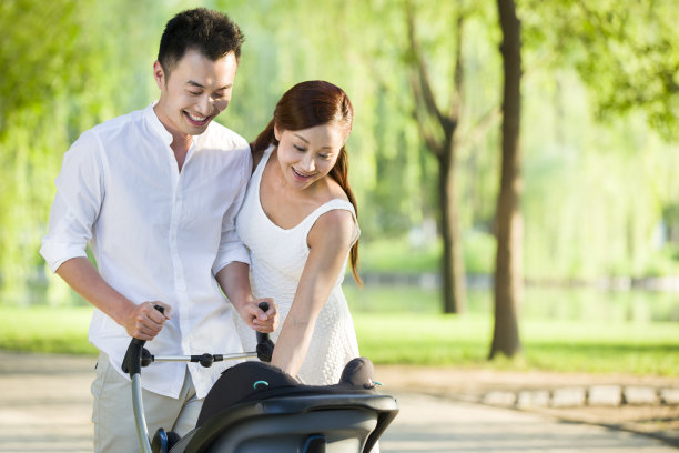 年轻情侣推着婴儿车散步图片下载
