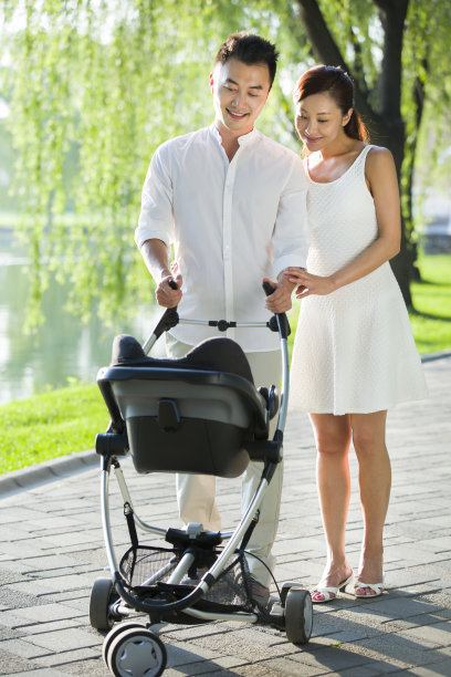 年轻情侣推着婴儿车散步图片下载