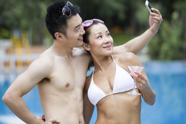 年轻情侣在泳池边自拍图片下载