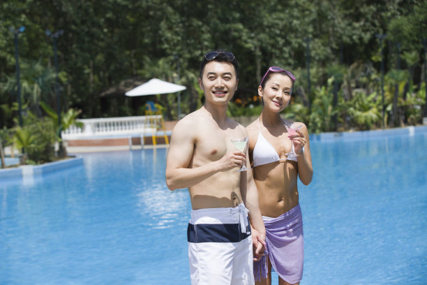 年轻男女在游泳池边散步图片下载