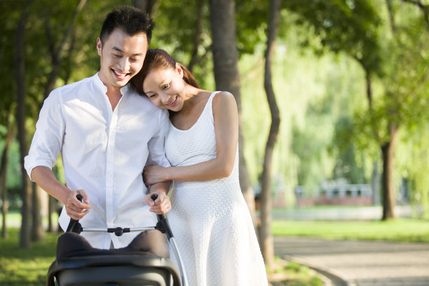 年轻情侣推着婴儿车散步图片下载