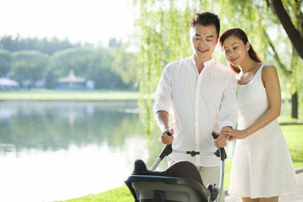 年轻情侣推着婴儿车散步图片下载