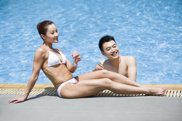 年轻情侣在泳池边休息图片下载