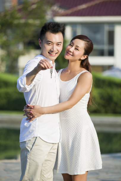 年轻情侣展示新房的钥匙图片下载