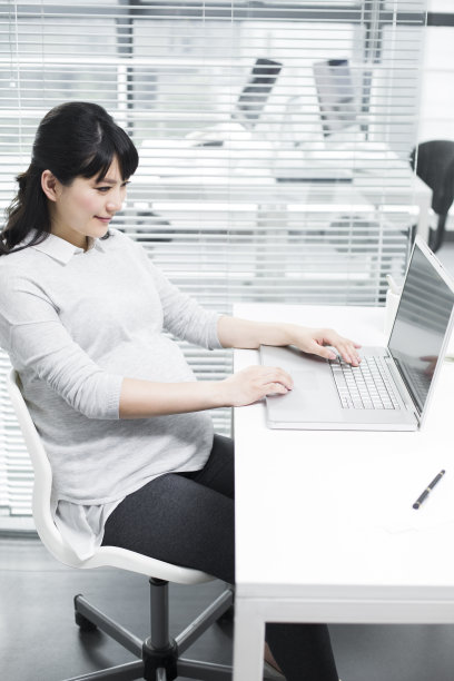 怀孕的商务女士使用笔记本电脑图片下载