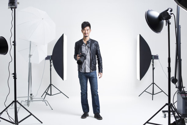 摄影师拿着相机站在摄影棚里图片下载