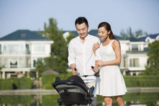 年轻情侣推着婴儿车散步图片下载