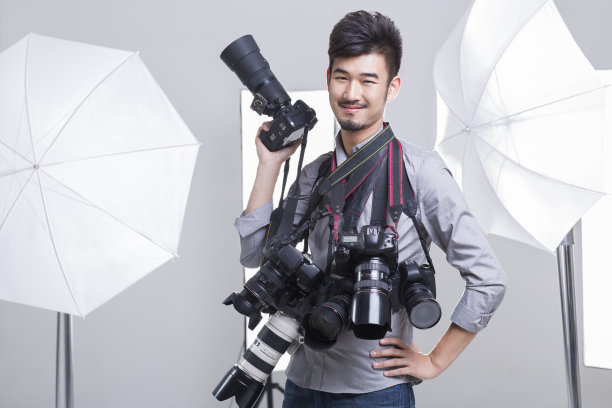 一个摄影师拿着很多单反相机图片下载
