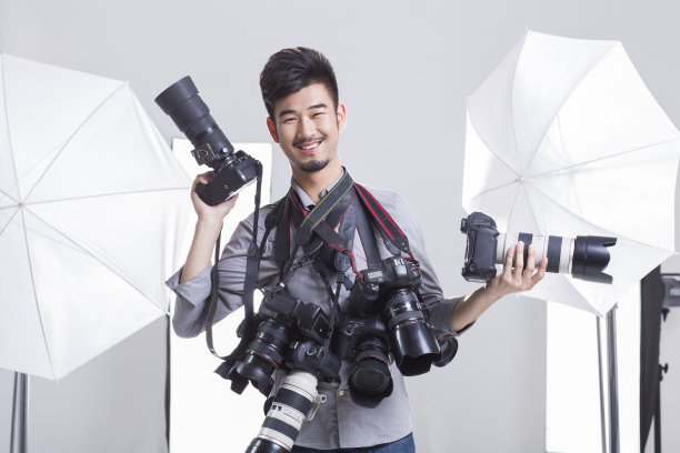 一个摄影师拿着很多单反相机图片下载