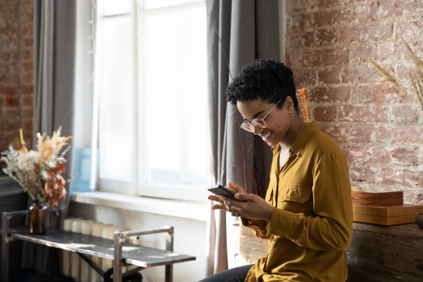 快乐的黑人女孩在现代家庭使用智能手机应用程序图片下载