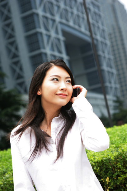 上海浦东写字楼旁一位女商务人士打手机图片下载